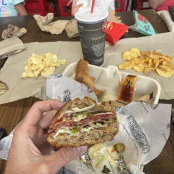 Firehouse Subs - a person holding a sandwich - Sandwiches Near Me - Richmond, Virginia