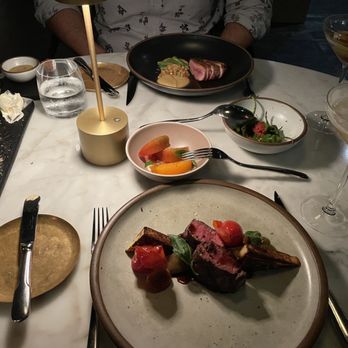 Bacchanalia - The main courses - lamb with tomato, duck with peaches, side dishes of summer tomatoes and shishitos. Bread to the side. - New American Near Me - Atlanta, Georgia