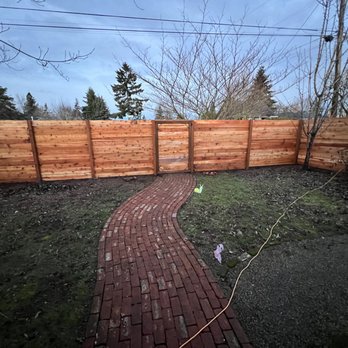 Yard Perfections - a brick path and a wooden fence - Landscaping Near Me