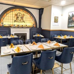 La Verona Restaurant - Main indoor dining area with fireplace, stained glass and artwork.