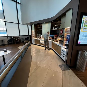 Delta Sky Club - a man standing at the counter - Airport Lounges Near Me - Boston, Massachusetts