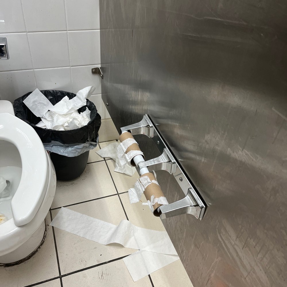 a bathroom with toilet paper on the floor a bathroom with toilet paper on the floor