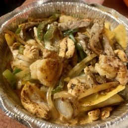 Delicious, fiesta nachos with bell peppers, onions, shrimp, steak, and chicken