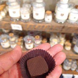 a hand holding a chocolate covered in chocolate a hand holding a chocolate covered in chocolate