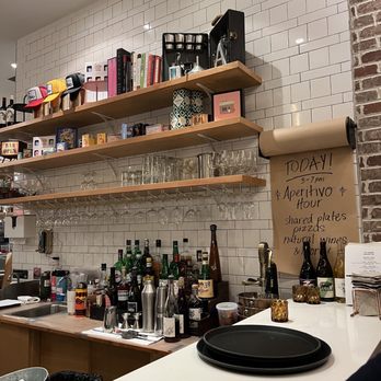 Fond - a bar counter with wine glasses and bottles on it - Salad Near Me - Dallas, Texas
