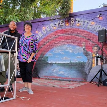Check It Enterprises - a man and woman standing in front of a mural - Music Venues Near Me - Washington, DC, District of Columbia