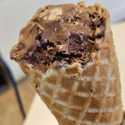 Blue Cow Ice Cream - A scoop of Blue Cow Patty Ice cream on a Waffle Cone.