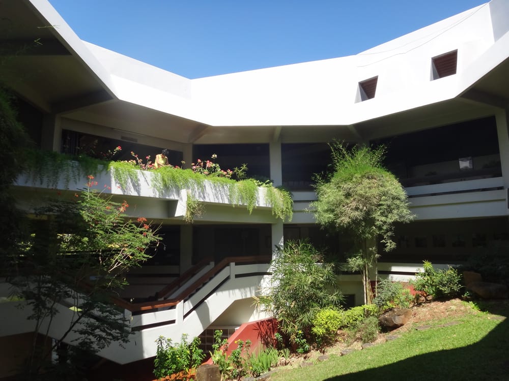 Exterior view of Robinsons Place Antipolo, showcasing the shopping mall's entrance with a prominent sign and surrounding vehicles parked in the lot.