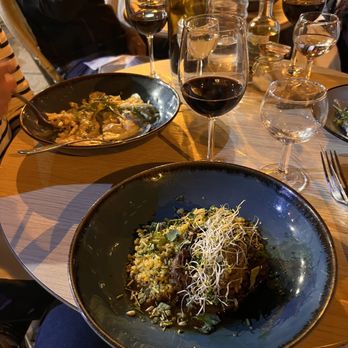 Bistrot Rougemont - Slow cooked lamb shoulder over bulgur wheat, topped with satay and some sprouts. In the background you see truffle and cheese raviolis. - French Near Me - Paris, 75