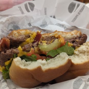 The Burger's Priest - a hand holding a sandwich - Burgers Near Me - Calgary, Alberta The Burger's Priest - a hand holding a sandwich - Burgers Near Me - Calgary, Alberta