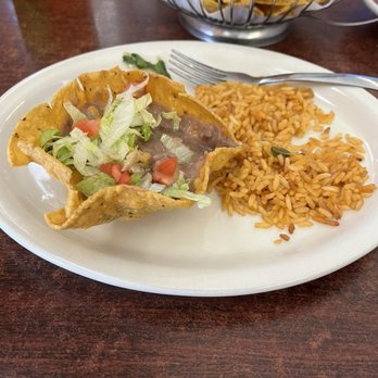 El Comal - Bean Chalupa with Mexican rice - A taco filled with lettuce, tomato, and beef, accompanied by Mexican rice on a white plate at a restaurant. - Mexican Near Me - Santa Fe, New Mexico