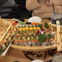 Sushi boat with white lady, dynamite, sunshine, AK, and toro roll