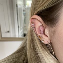 Midtown Tattoo & Piercing - conch piercing with a solid yellow gold garnet gemstone jewelry
