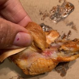 a hand holding a piece of pizza