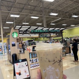 a hand holding a cup of iced coffee a hand holding a cup of iced coffee
