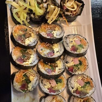 Nawabari - Kimbap - A rectangular plate holds multiple sushi rolls filled with vegetables, fish, and rice, garnished with shredded vegetables and sesame seeds. - Korean Near Me - Flushing, New York