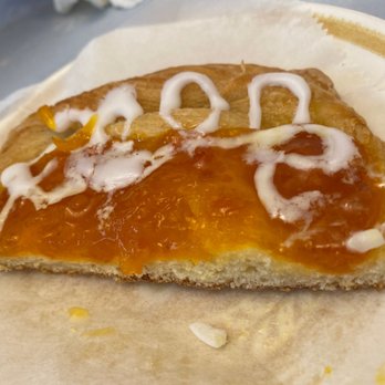 The Bakery Nook - Sorry sampled it before I took the picture.  Apricot Danish. Yum. - A close-up of a slice of apricot Danish pastry with icing and glaze, placed on parchment paper, showing its flaky crust and fruit filling. - Bakeries Near Me - Coplay, Pennsylvania