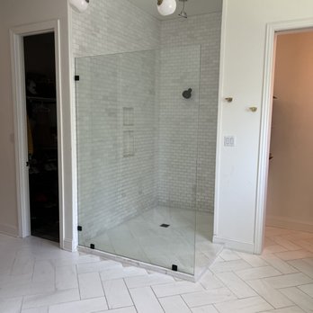 Austin Sealing Services - a shower with a glass door - Flooring Near Me