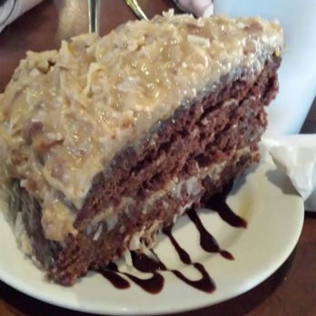 Sandy McGee's - HUGRE portion of German Chocolate Cake. Boy it feeds like 3-4 people at least (coming from a food lover: seriously feeds a family of four) - American Near Me - Richmond, Texas Sandy McGee's - HUGRE portion of German Chocolate Cake. Boy it feeds like 3-4 people at least (coming from a food lover: seriously feeds a family of four) - American Near Me - Richmond, Texas