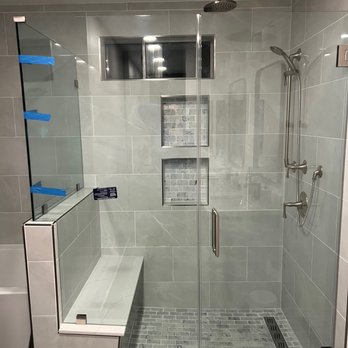 Laguna Bay Developing - Walk-in shower. Note the rain shower head, bench, and cut-outs for soap etc - General Contractors Near Me