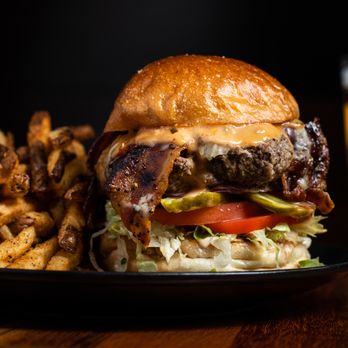 Von's 1000Spirits - Stacked classic burger with bacon, lettuce, tomato, and sauce served with added seasoned fries and a cold beer at Von's 1000Spirits - Cocktail Bars Near Me - Kirkland, Washington Von's 1000Spirits - Stacked classic burger with bacon, lettuce, tomato, and sauce served with added seasoned fries and a cold beer at Von's 1000Spirits - Cocktail Bars Near Me - Kirkland, Washington