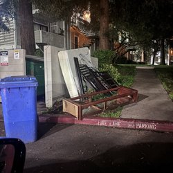 My Dad's Moving - Illegally dumped furniture and broken glass next to complex dumpster.