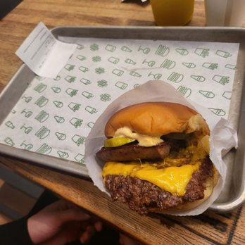 Shake Shack Rice Village - Lockhart burger- pickles, shack sauce, sausage, cheese and patty with lettuce - Burgers Near Me - Houston, Texas Shake Shack Rice Village - Lockhart burger- pickles, shack sauce, sausage, cheese and patty with lettuce - Burgers Near Me - Houston, Texas