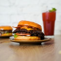 Joyo Burger - Smash burger with cheddar, bacon, and fresh toppings.
Smash burger avec cheddar, bacon et garnitures fraîches.