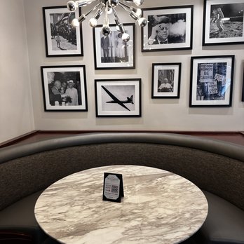 The Cloakroom Kitchen & Bar - cute table with JFK pics behind - American Near Me - Atlanta, Georgia