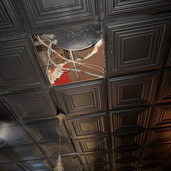 The Quarter Bar - a broken ceiling with a clock in the background - Bars Near Me - Dallas, Texas