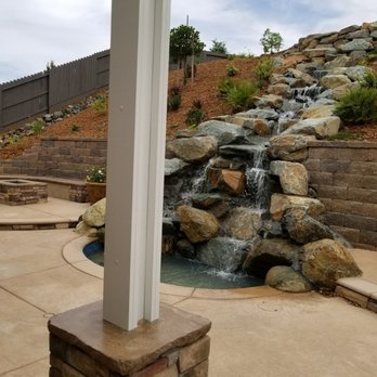 Allen Block Wall With A Blue Rock Waterfall Running Inbetween Fire