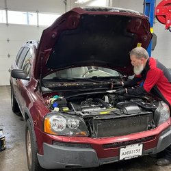 Esty's Auto Center - Certified technician inspecting a vehicle under the hood at Esty's Auto Center, providing reliable engine repair and car maintenance.