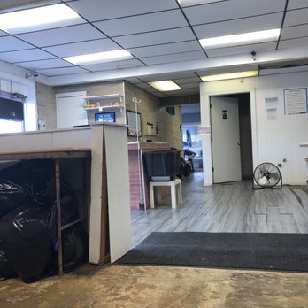 Action Laundry Wixom - Partially renovated space and floor boards aren't in place). Random trash bags under a gross, rusty folding table. - Laundromat Near Me - Wixom, Michigan