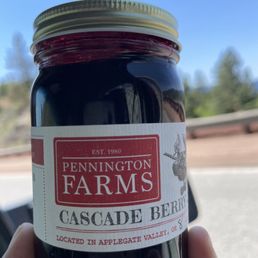 a hand holding a jar of preserves a hand holding a jar of preserves
