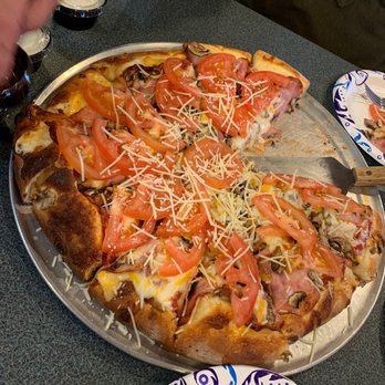 Second Avenue Pizza - a person cutting a pizza - Pizza Near Me - Sandpoint, Idaho Second Avenue Pizza - a person cutting a pizza - Pizza Near Me - Sandpoint, Idaho