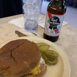 a burger and pickles on a plate a burger and pickles on a plate