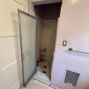 Lynx construction - The tiny, cramped shower with no light or fan to reduce moisture or mildew. Yuck! - General Contractors Near Me
