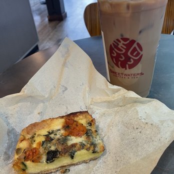 Sweetwaters Coffee & Tea - Large iced latte with skim milk and SF brown sugar syrup. Spinach artichoke quiche - Coffee & Tea Near Me - Austin, Texas