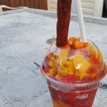 La Michoacana - a plastic cup of fruit with a stick sticking out of it - Ice Cream & Frozen Yogurt Near Me - Romeoville, Illinois