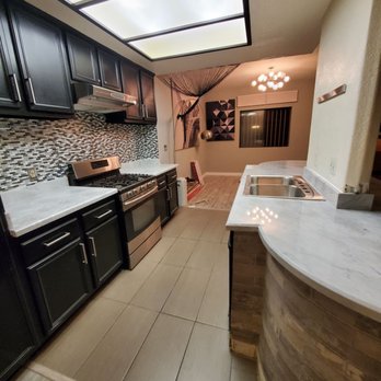 JNA Marble & Granite - a kitchen with black cabinets and white countertops - General Contractors Near Me - Los Angeles, California JNA Marble & Granite - a kitchen with black cabinets and white countertops - General Contractors Near Me - Los Angeles, California
