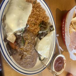 Steak Burrito topped with queso cheese,