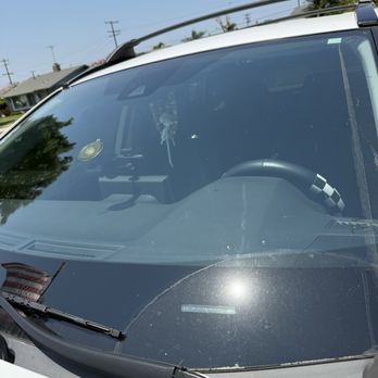 Glass First Aid - Photo of the crack caused by a rock that was kicked up from another vehicle while driving on the freeway. - Windshield Installation & Repair Near Me