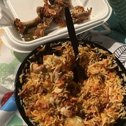 Ammi’s Kitchen & Grill - Chicken Biryani in the white container all the bones and top middle the chicken. Rest is rice and potatoes.