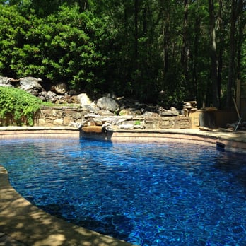 East Coast Pools - a pool with a waterfall in the background - General Contractors Near Me - Alfred Station, New York East Coast Pools - a pool with a waterfall in the background - General Contractors Near Me - Alfred Station, New York