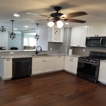 The Day Husband - a kitchen with white cabinets and black appliances - General Contractors Near Me The Day Husband - a kitchen with white cabinets and black appliances - General Contractors Near Me