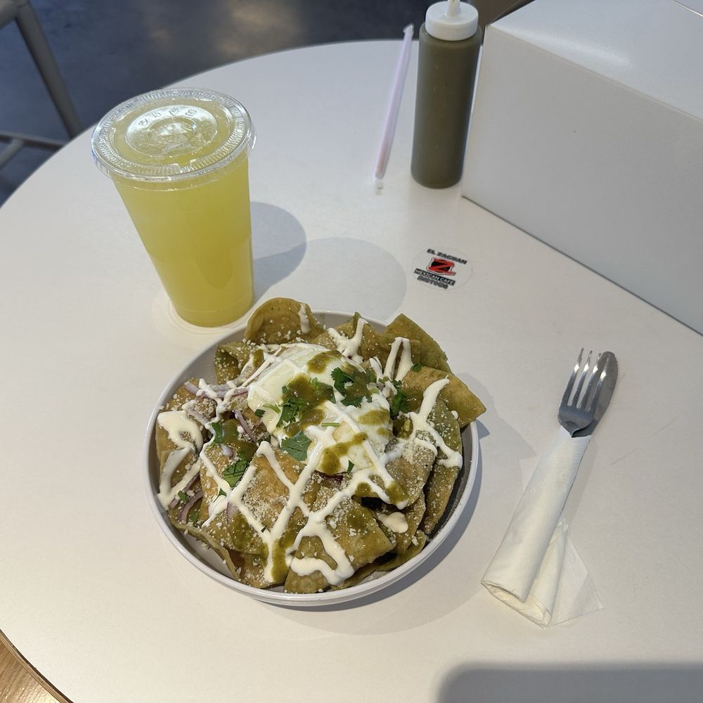 Un agua de piña y unos chilaquiles verde con huevos medio.  A pineapple water and chilaquiles verde with an over medium egg.