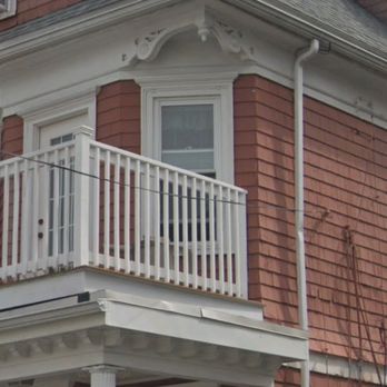 East Lynn Construction - a red house with white balconies - Siding Near Me