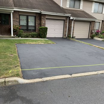 Blacktop Unlimited - a driveway with a yellow tape - Masonry/Concrete Near Me - Wantagh, New York Blacktop Unlimited - a driveway with a yellow tape - Masonry/Concrete Near Me - Wantagh, New York
