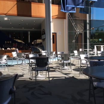 Indianapolis Central Public Library - Lots of tables and chairs in the atrium/lobby with a cafe in the background - Libraries Near Me - Indianapolis, Indiana