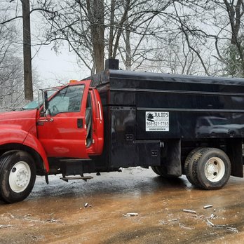 Julio's Tree Services - a red dump truck parked on the side of the road - Tree Services Near Me
